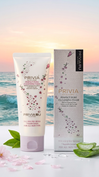 PRIVIA IU Perfect Pure Cleansing Foam shown as a white squeeze tube next to its matching box, set against a beach sunset background with aloe vera leaves and petals.